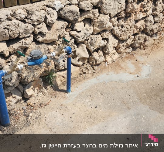 שני ברזים כחולים ליד קיר אבן